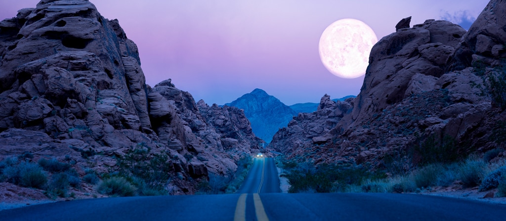 Une lune suspendue au-dessus d'une autoroute dans le désert