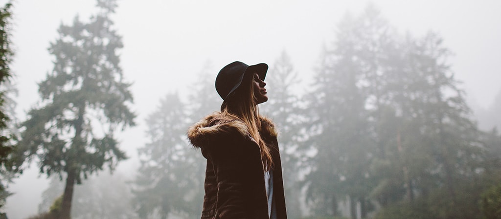 Une femme marche dans la forêt à la fin d'un orage