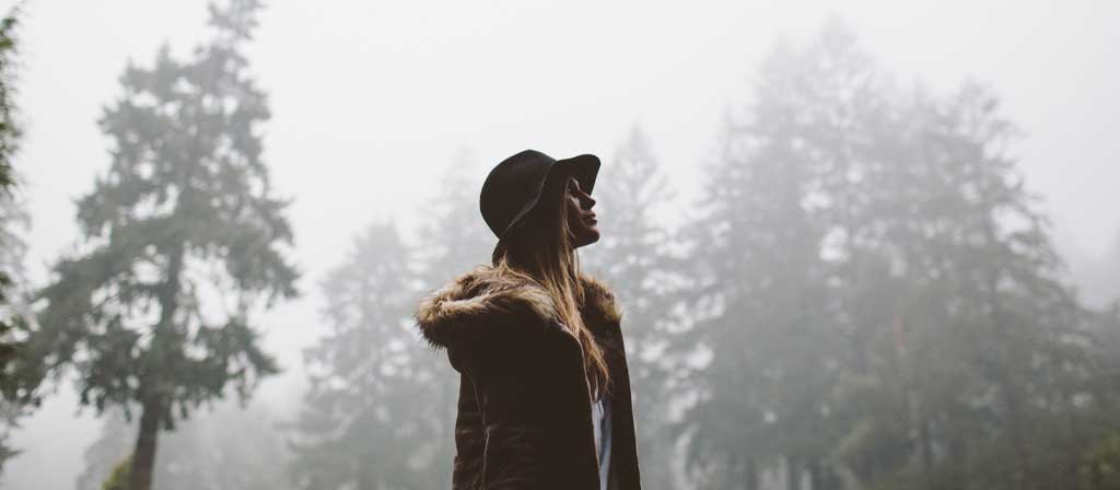 Une femme marche dans la forêt après la fin d’une tempête de pluie