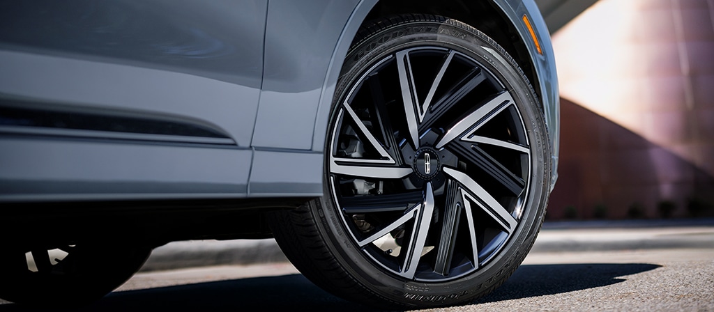 Les jantes en aluminium usiné brillant de 22 po avec évidements peints de couleur ébène sont présentées sur un modèle Lincoln Black Label Aviator® 2026.