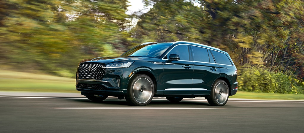 Un Lincoln VUS Aviator® 2026 circulant sur une route forestière
