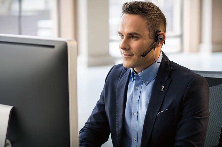 Un représentant du service à la clientèle de Lincoln portant un casque d'écoute est assis à un ordinateur