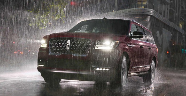 Un Lincoln Navigator rouge sous la pluie utilisant ses essuie-glaces à détecteur de pluie