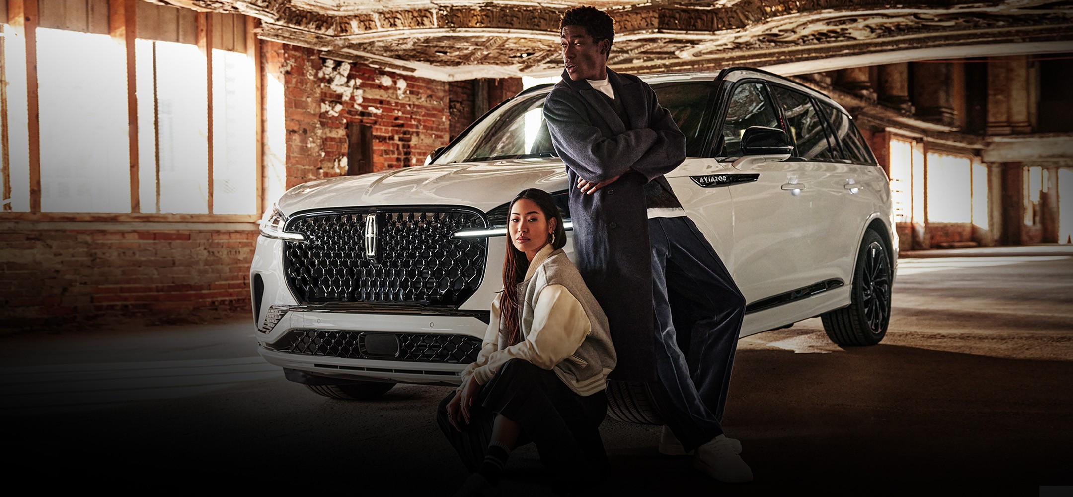 Deux personnes devant un véhicule Lincoln blanc