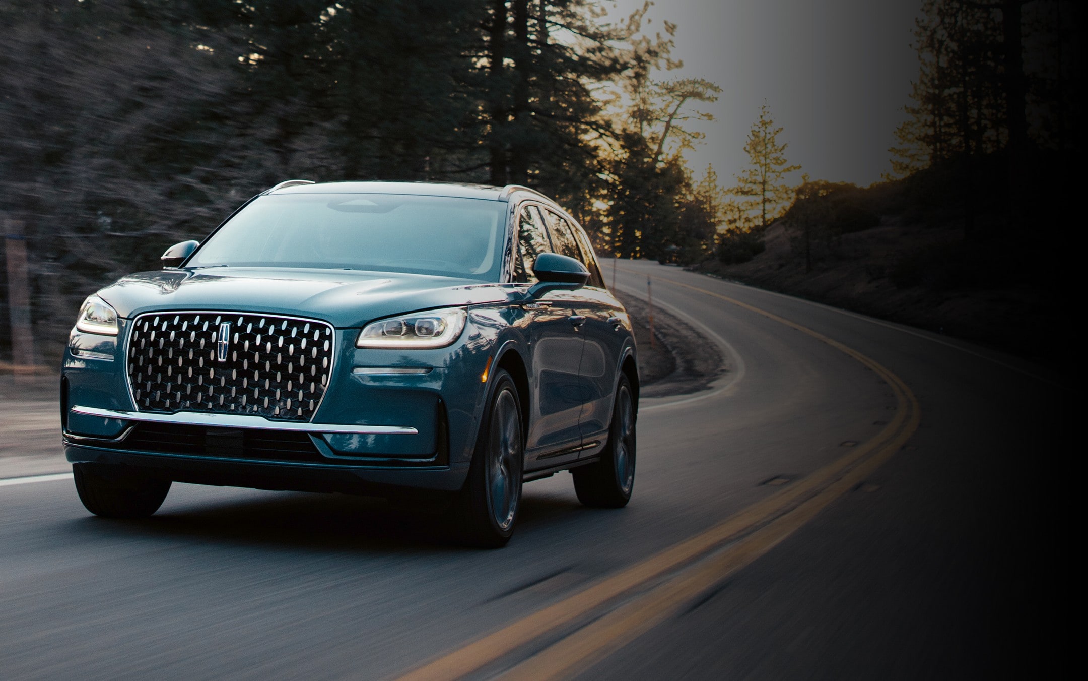 Le Lincoln Corsair 2025 de couleur extérieure bleu murmure est conduit sur un pont la nuit