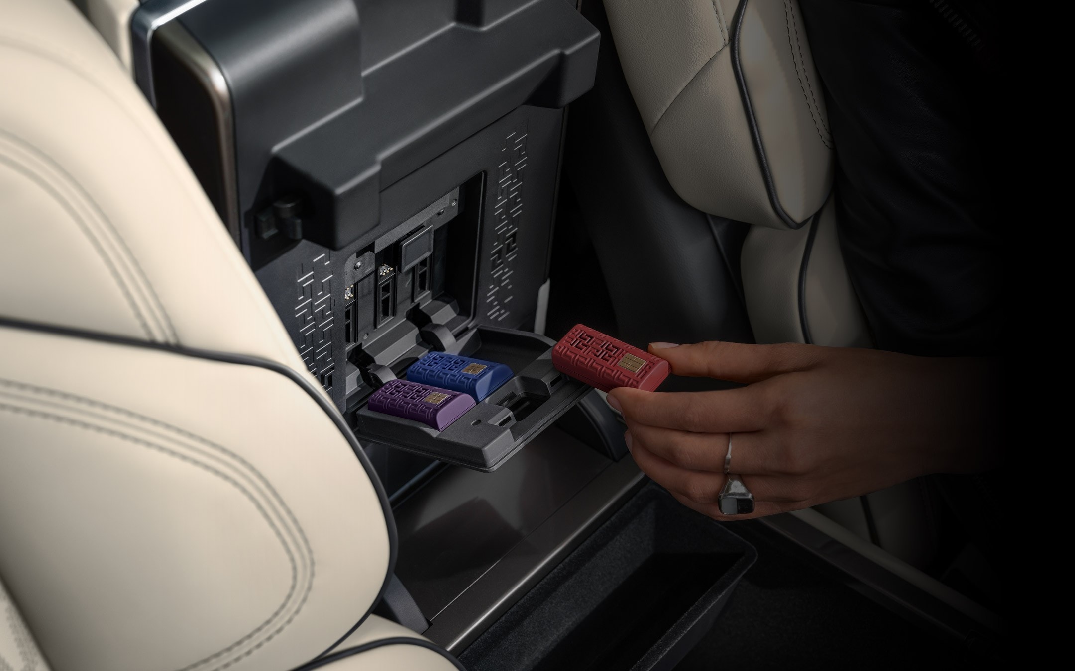 Une main insère une cartouche de parfum numérique dans le bac de rangement ouvert d’un Lincoln Nautilus 2026