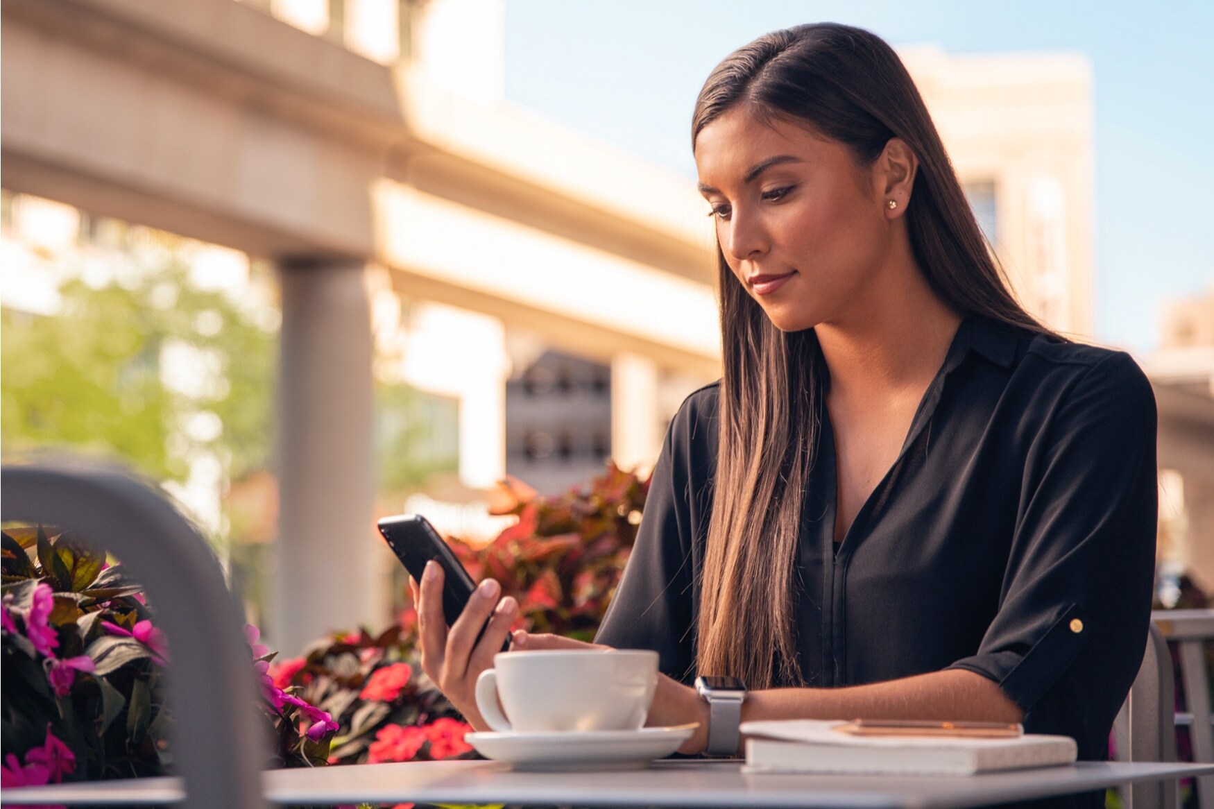 Une femme regarde son téléphone intelligent à l’extérieur.