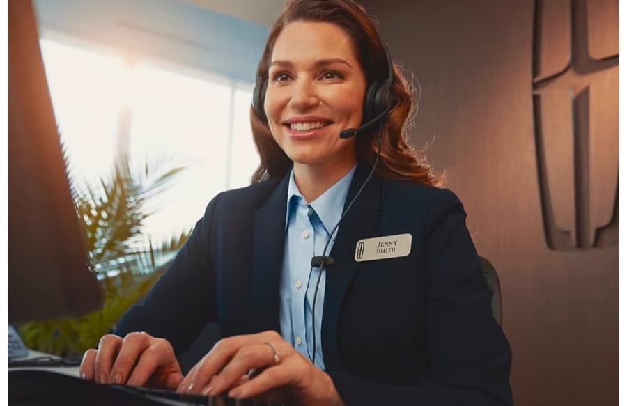Une femme tape sur un clavier tout en parlant dans un casque.