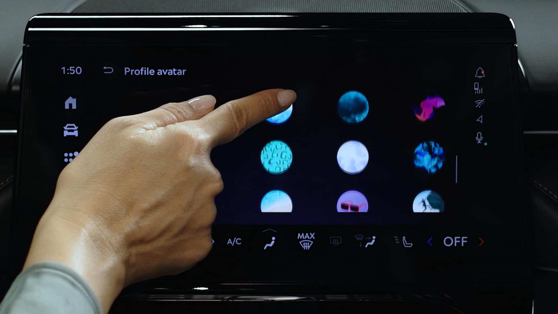 La main d’une femme touche l’écran central d’un véhicule Lincoln.