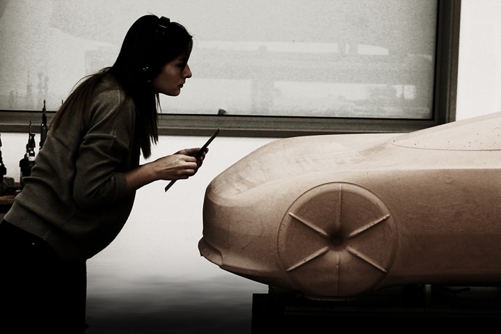 Un designer examine une maquette de voiture