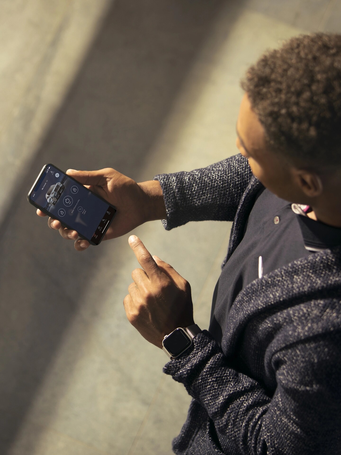 Un homme regarde l’application Lincoln sur son téléphone intelligent, en pointant à l’écran