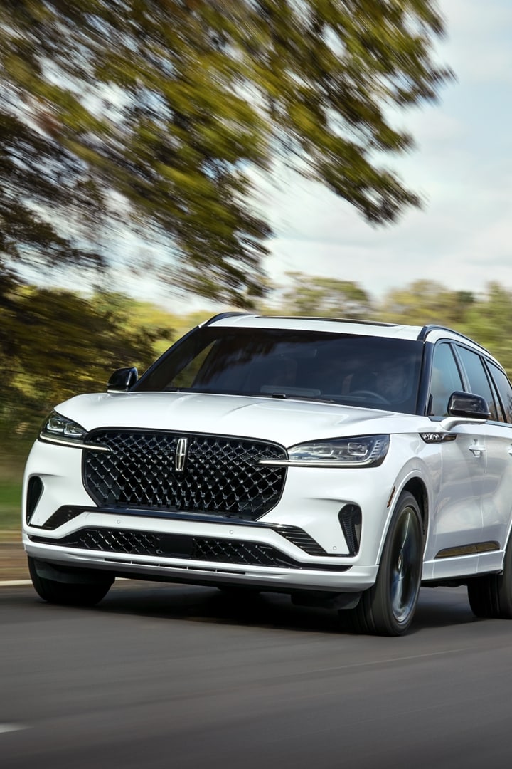 Un Lincoln Aviator 2025 conduit sur une autoroute près d’une forêt