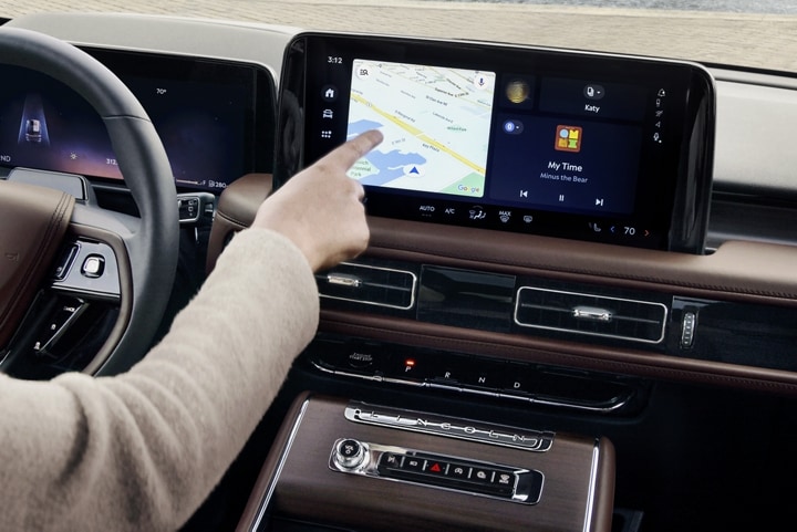Une personne tape sur l’écran tactile de la console centrale d’un Lincoln Aviator 2025