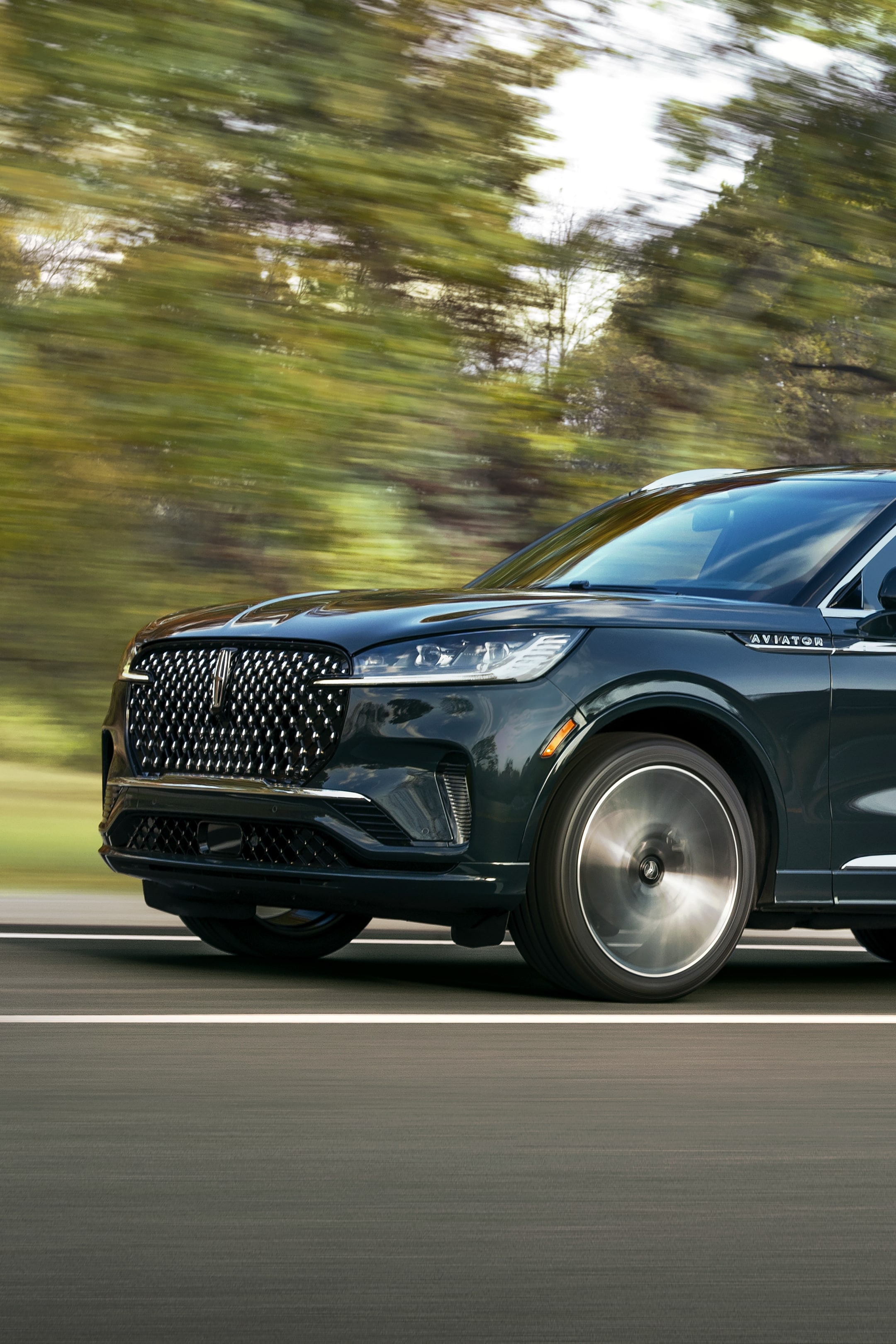 Un Lincoln Aviator Black Label 2025 est conduit sur une route de campagne.