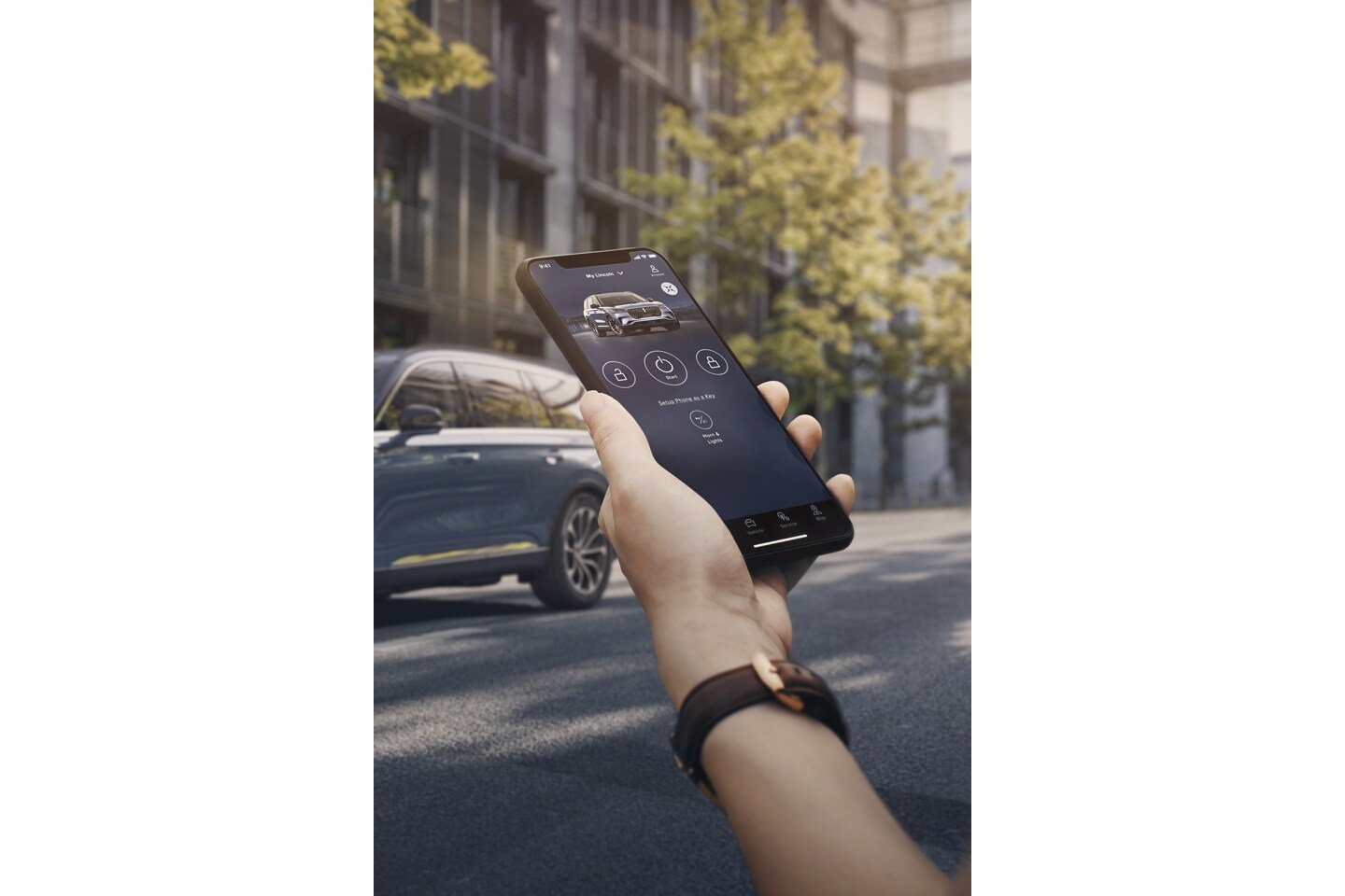 Une personne tient un smartphone à la main alors qu'elle s'approche d'un véhicule Lincoln.