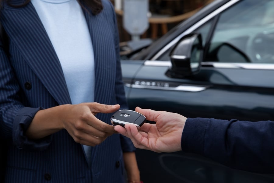 Un détaillant Lincoln remet à un client la clé de son nouveau véhicule.