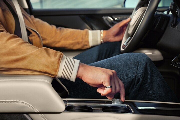 La main d’une personne conduisant un Lincoln Corsair 2025 est montrée tournant un bouton central pour changer de mode de conduite