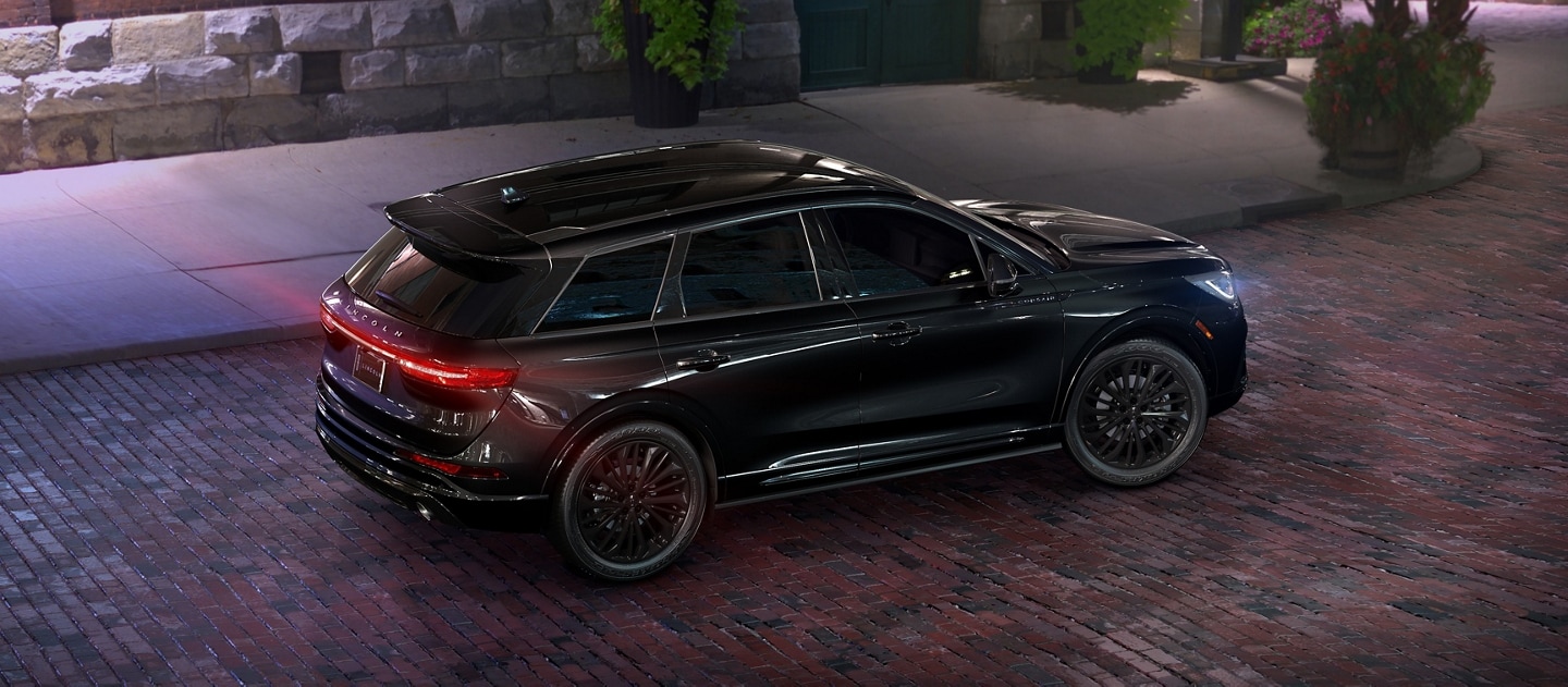 Un Lincoln Corsair 2025 est stationné dans une rue de briques la nuit