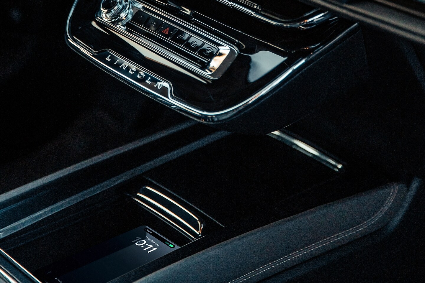 Une main place un téléphone cellulaire sur le chargeur sans fil en option à l’intérieur d’un Lincoln Corsair 2025.