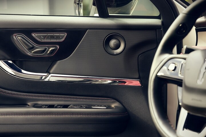 Un haut-parleur du système audio Revel® à 14 haut-parleurs offert en option est illustré sur le panneau de la porte avant du conducteur