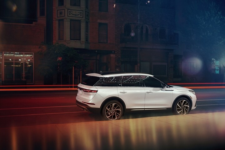 Un Lincoln Corsair 2026 est conduit en ville sur une autoroute la nuit