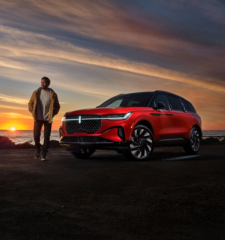 Un homme marche près d’un VUS Lincoln Nautilus® 2025 pendant que la séquence d’accueil Lincoln Embrace se produit