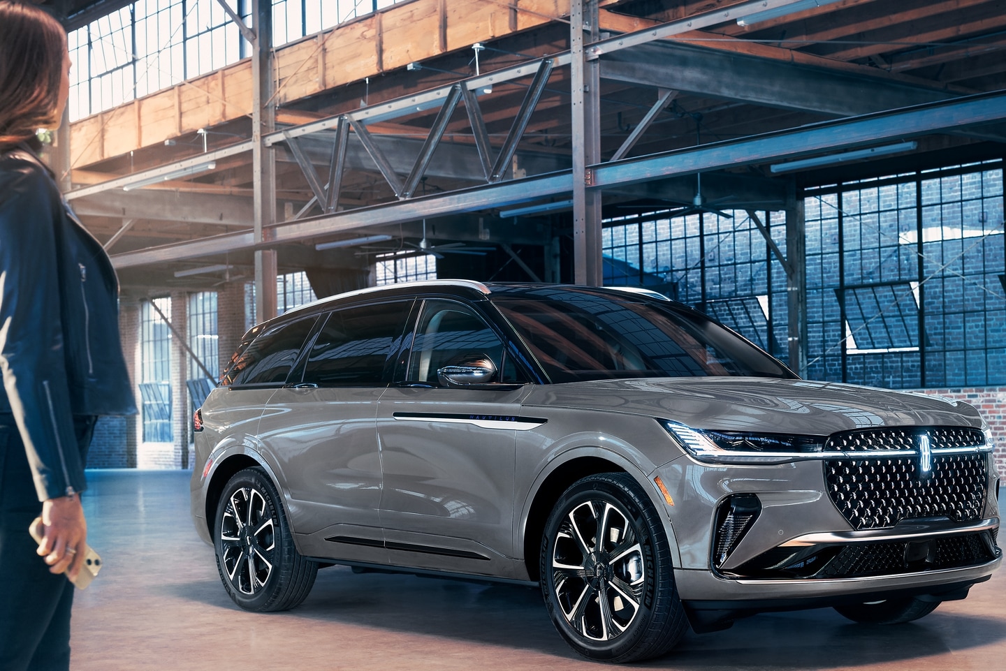 Une personne s’approche d’un Lincoln Nautilus tenant un téléphone mobile