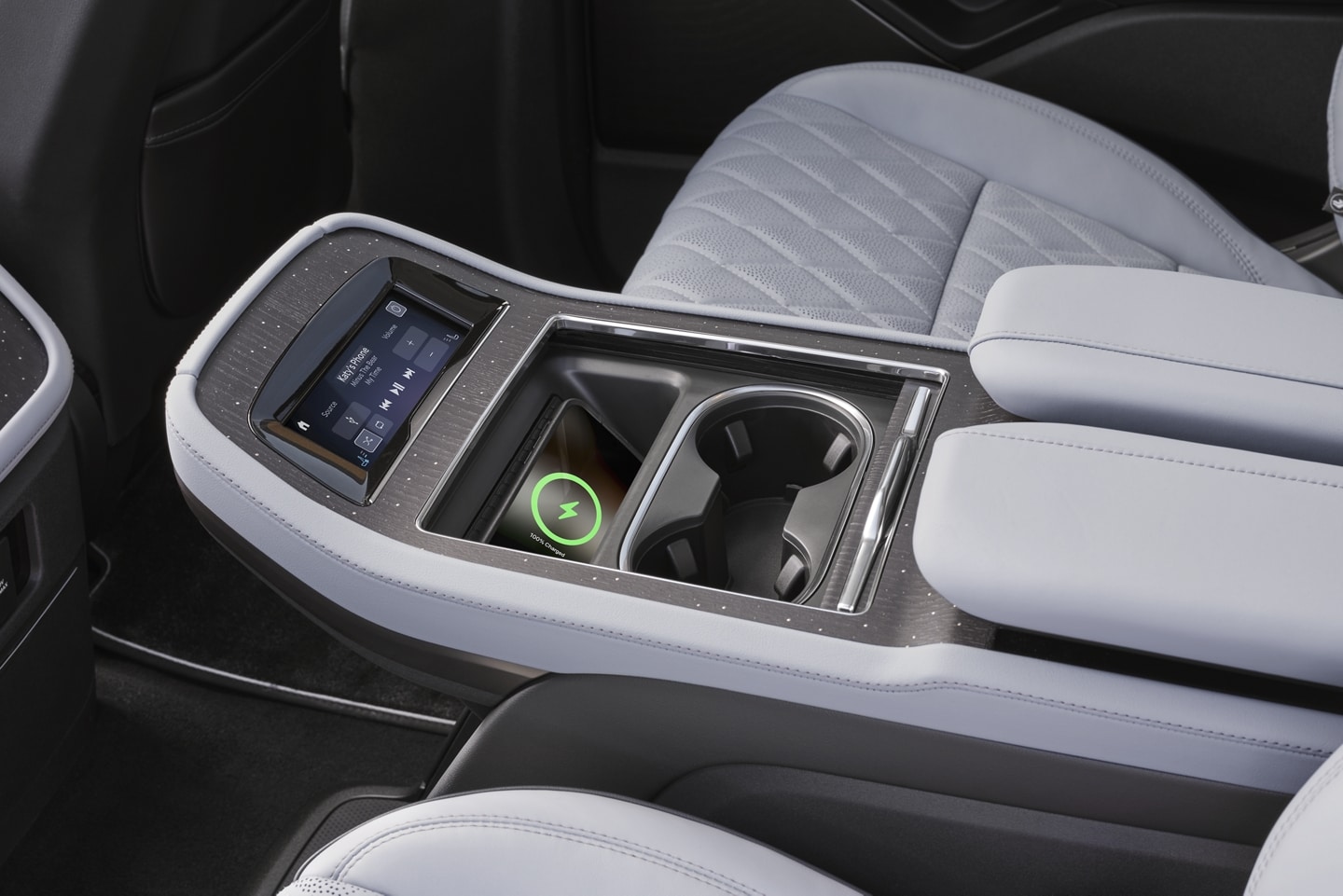 Un téléphone se recharge sur un tapis de recharge sans fil dans la console de la deuxième rangée d’un VUS Lincoln Black Label Navigator® 2025