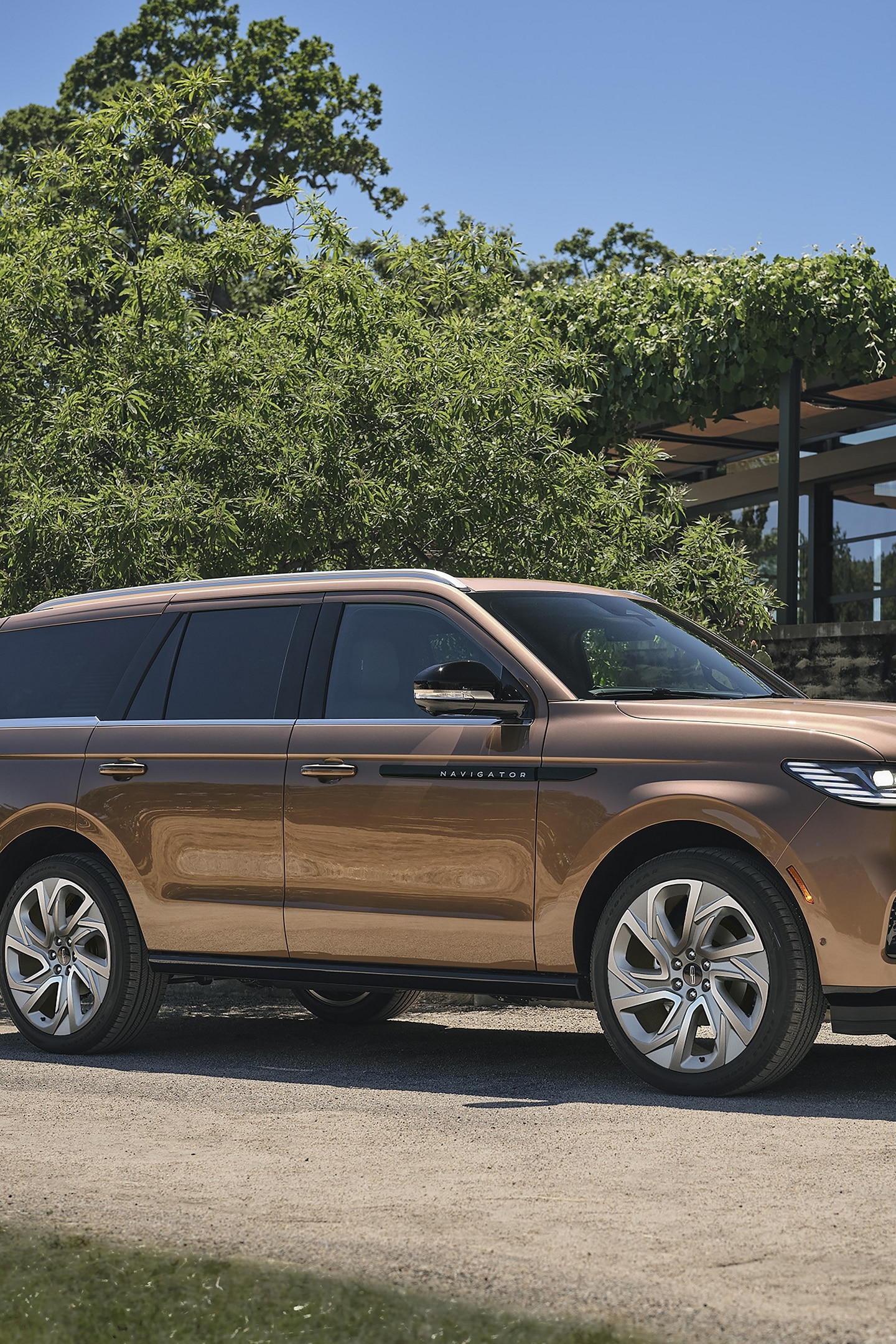 Un VUS Lincoln Black Label Navigator 2025 est stationné à côté d’une maison de style moderne